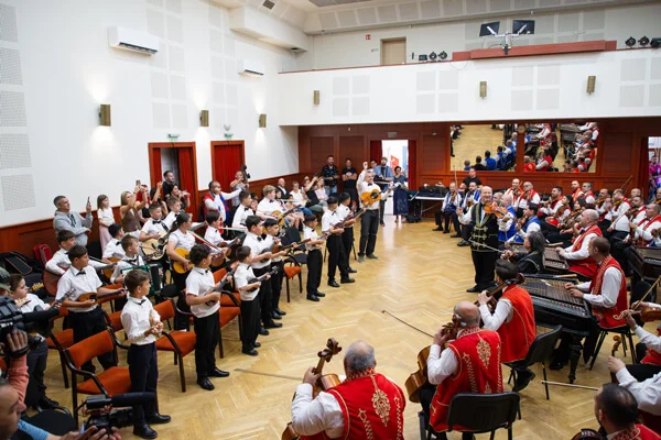 A SUGO Tamburazenekar és a 100 Tagú Cigányzenekar egymással szemben muzsikál a Csokonai Rendezvényházban.