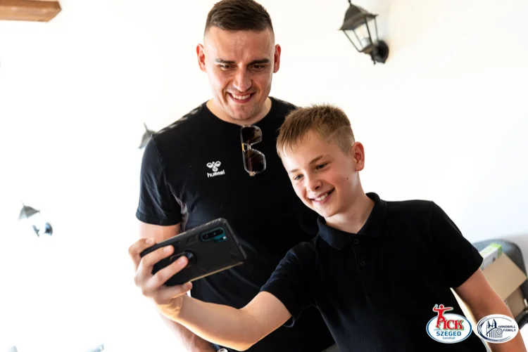 Fiú mobiltelefonnal közös szelfit készít a mosolygó PICK Szeged játékossal a sükösdi találkozón