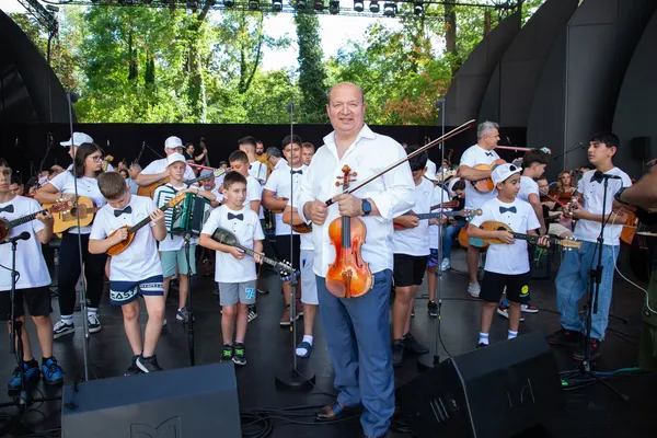 Egy hegedűs zenész áll a SUGO fiatal muzsikusai előtt a főpróbán, kezében hangszerével, a koncert kezdete előtt.